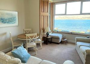 泰纳布鲁厄赫Kames View Apartment的客厅设有一张沙发和一张桌子,享有海景。