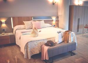 马里亚诺努埃瓦广场酒店的一间卧室配有一张大床,在长凳上戴着帽子