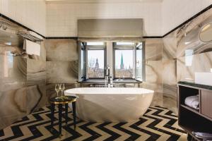 里加Grand Poet Hotel and SPA by Semarah的一间带大浴缸和窗户的浴室