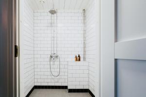 KauhajokiSalaisen Puutarhan Majatalo的浴室铺有白色地铁瓷砖,配有淋浴。