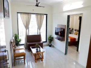 纳威孟买Hotel Satyam Residency的带沙发、床和镜子的客厅
