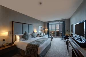 杜科姆杜古姆皇冠假日酒店的一间酒店客房,配有一张大床和一台平面电视