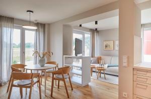 赫亨基尔兴Bades Huk Ferien-Resort的用餐室以及带桌椅的起居室。