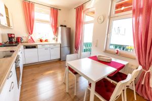耶拿Ferienwohnung Jenzigblick的厨房配有白色的桌子、椅子和窗户。