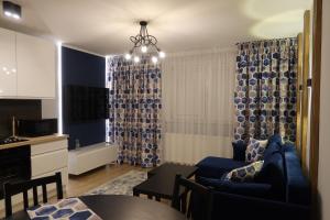 格但斯克Amart的一间带蓝色沙发的客厅和一间厨房