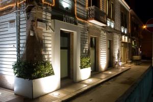福贾Residenze Romano Ristorante & SPA albergo diffuso - WHITE的街上的一座有植物点的建筑