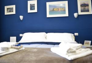 那不勒斯Il Viaggio di Dante Historical Center的一间拥有蓝色墙壁的卧室和一张带毛巾的床