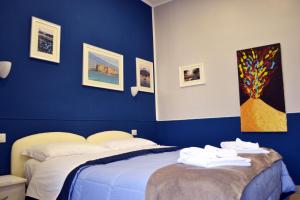 那不勒斯Il Viaggio di Dante Historical Center的蓝色卧室,配有带毛巾的床