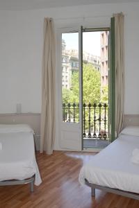 巴塞罗那克拉里斯公寓式酒店的一间卧室设有两张床和大窗户