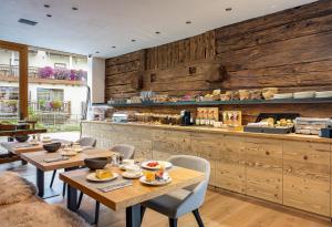 利维尼奥Vetta Alpine Relax的餐厅拥有木墙和桌椅