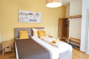 LinsbergGästezimmer Victoria的一间卧室配有一张带黄色枕头的大床