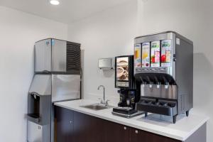 皇后区Avion Inn Near LGA Airport, Ascend Hotel Collection的厨房配有水槽和咖啡机