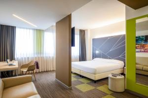 阿格拉泰布里亚恩扎Mercure Milano Agrate Brianza的配有一张床和一张书桌的酒店客房
