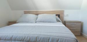 塞埃APARTAMeNTOS DON MANUEL A的一间卧室配有一张带木制床头板的床和2个床头柜。