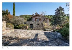 皮安迪斯科Fattoria Casamora - Villa La Nocciolina的一座古老的石头房子,有石头车道