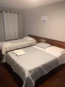 圣若泽-达科罗阿格兰迪Pousada Lá Na Praia的配有2张床的客房内配有白色床单和毛巾