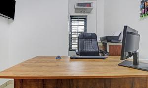 阿鲁法Treebo Trend Nirupama Apartment的办公室,配有书桌、电脑和椅子