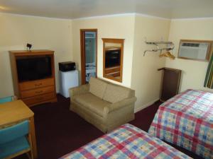 绿湾陶尔汽车旅馆的酒店客房配有床、沙发和电视。