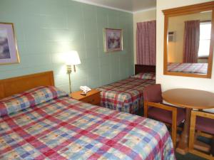 绿湾陶尔汽车旅馆的酒店客房设有两张床、一张桌子和镜子