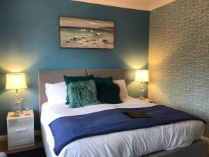 桑当The Drey的一间卧室配有一张蓝色墙壁的床和两盏灯。