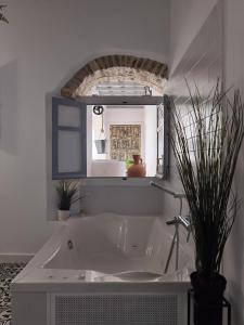 麦地那西多尼亚Casa del Sacramento - CASITA CON ENCANTO的浴室配有浴缸及镜子