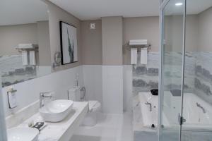 埃斯特城Bisinii Boutique Hotel的一间带两个盥洗盆和淋浴的浴室