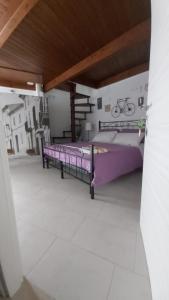 普蒂尼亚诺Il Vicolo b&b的阳台卧室配有紫色床