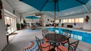 布赖森城Stonebrook Lodge Bryson City的游泳池旁带桌椅的天井