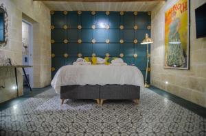 森格莱阿Senglea Suites的一间卧室配有一张蓝色墙壁的床