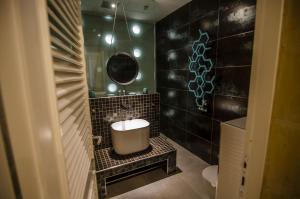 森格莱阿Senglea Suites的浴室设有黑色瓷砖墙和水槽。
