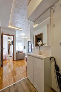 兹拉蒂博尔Apartman Tajena的一间带白色橱柜的厨房和一间客厅
