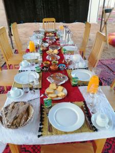 姆哈米德Luxury Camp desert Maroc Tours的一张长桌,上面放着食物板