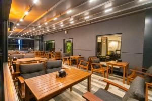 特拉布宗Şehrar Suite Hotel的配有木桌和椅子的餐厅