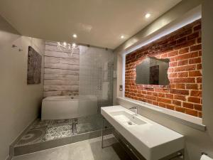 诺里奇公园农场酒店的一间带白色水槽和砖墙的浴室