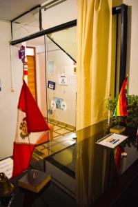 马丘比丘Runas Inn Machupicchu的一间设有玻璃桌和旗帜的房间