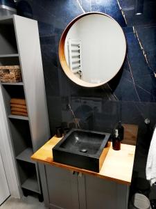 斯图托沃Apartament Sand&Blue的浴室设有黑色水槽和镜子