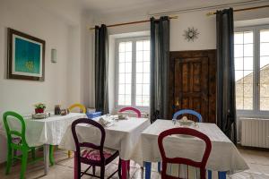 洛里La Chaumière, Demeure d'hôtes的用餐室配有2张桌子和五颜六色的椅子