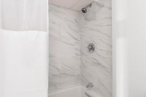 比弗利The Beverly的一间设有白色大理石墙壁和淋浴的浴室