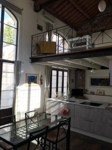 彼得拉桑塔Il Vecchio Studio的一间带玻璃桌的用餐室和一间厨房