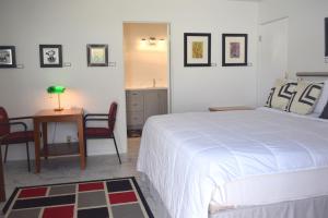 棕榈泉西网球俱乐部艺术民宿的卧室配有一张床和一张桌子及椅子