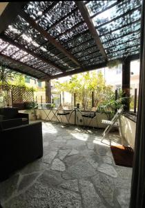 圣雷莫Locanda Sapori的一个带凉棚和桌椅的庭院