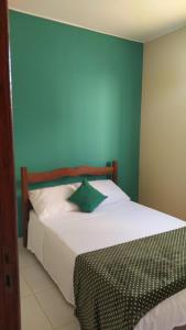 卡皮托利乌Cantinho Xodó的卧室配有白色床和蓝色墙壁