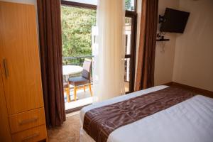 基加利Ndaru Luxury suites的一间卧室配有一张床,阳台配有桌子