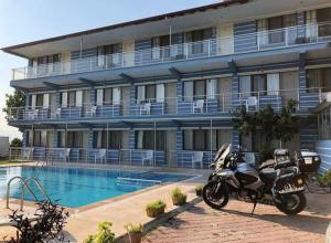帕莫卡莱Hotel Goreme Sakura的停在酒店前的摩托车,带游泳池