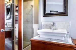 魁北克市逸轩综合酒店的浴室配有白色水槽和淋浴。