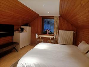 Mont-de-l'EnclusB&B Le Reclus的一间卧室配有一张床、一张桌子和一个窗户。
