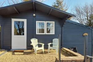 CoolnaconDelightful Studio Log Cabin , with Sauna的蓝色小房子前面的两把椅子