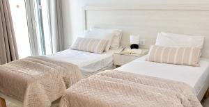 阿利卡纳斯Lightful Attic at Regina Apartments的一间卧室设有两张床和窗户。