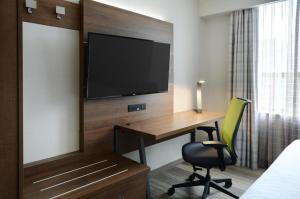 多伦多多伦多市中心快捷假日酒店的酒店的客房,配有书桌和墙上的电视