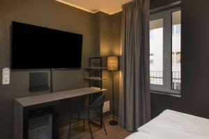 奥斯陆斯堪迪克瓦伦卡酒店的一间卧室配有电视、一张床和一张书桌